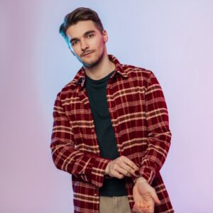 Handsome fashion model man in fashionable clothes in studio. Male portrait